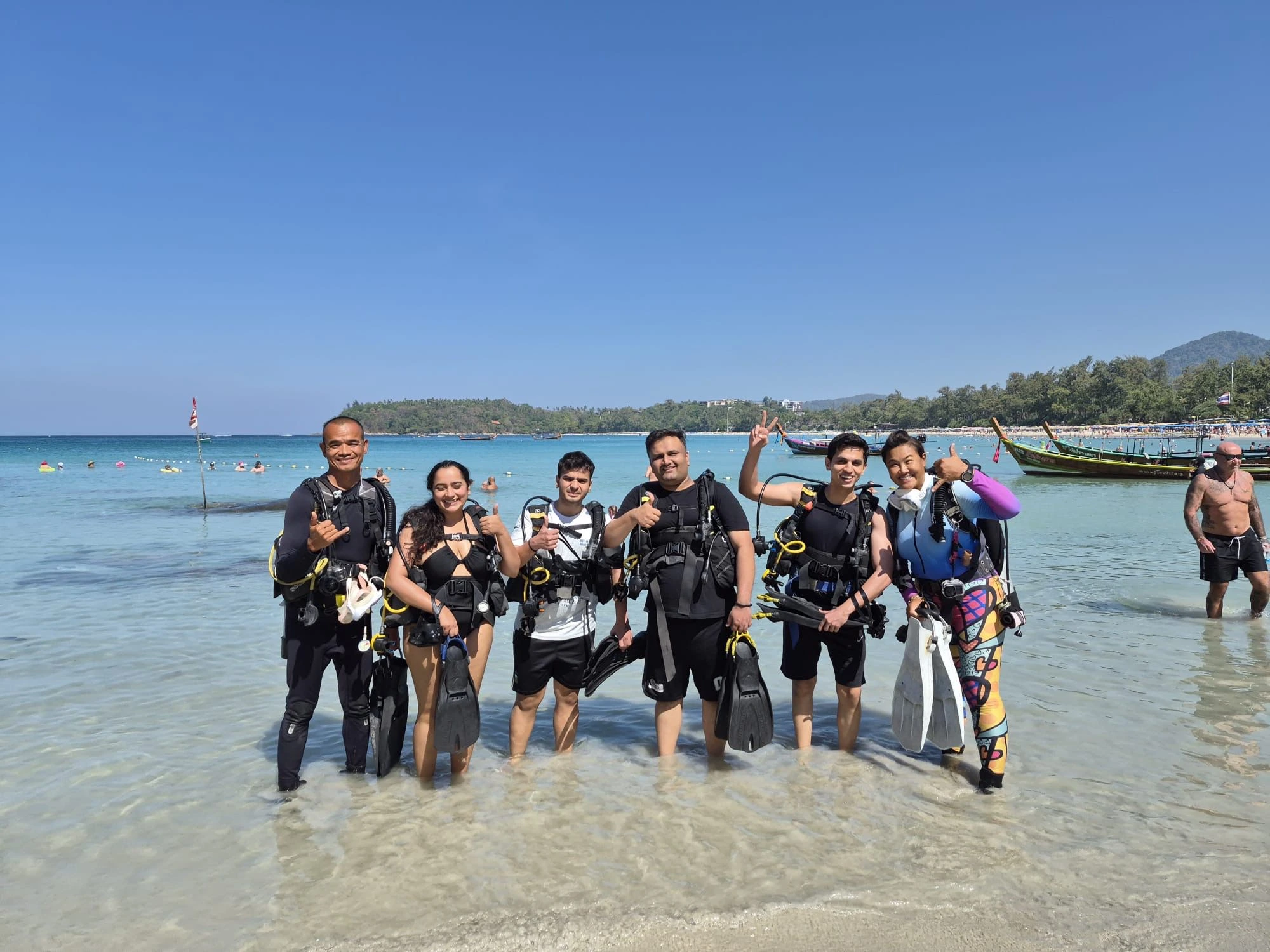 Scuba divers walking directly into the water at Kata Beach with SSS Phuket